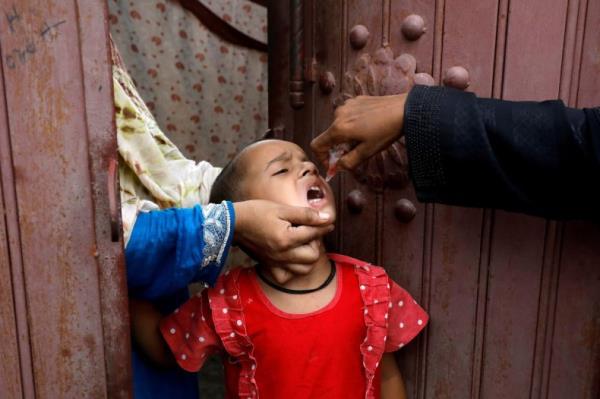 A girl receives polio vaccine drops, during an anti-polio campaign, in a low-income neighborhood as the spread of the coro<em></em>navirus disease (COVID-19) continues, in Karachi, Pakistan July 20, 2020. 